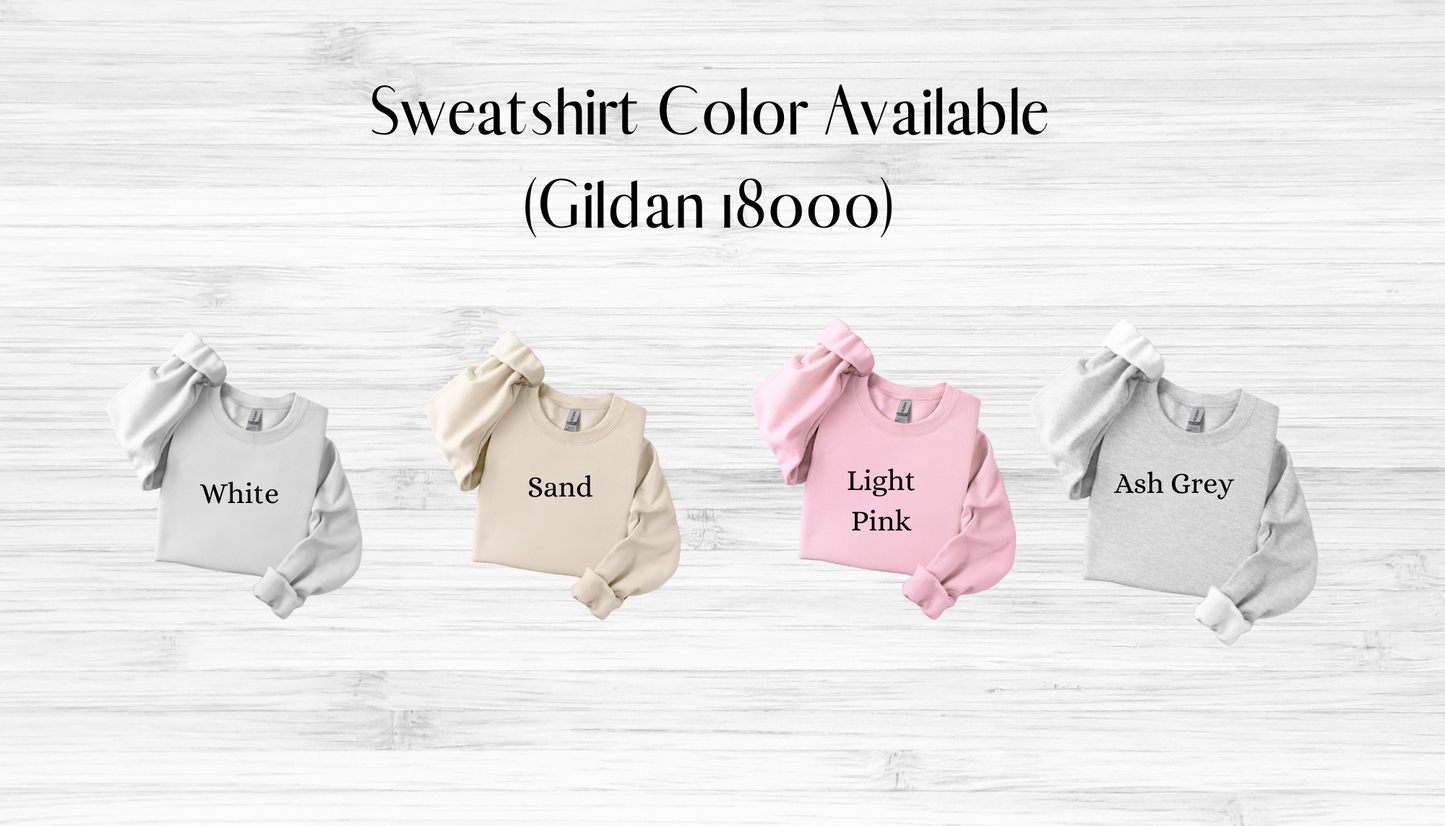 Four sweatshirts in different colors on a wooden surface with text indicating color options.