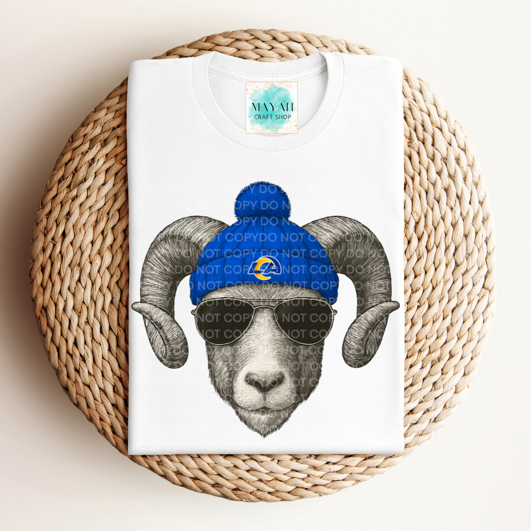 White t-shirt with a graphic of a ram wearing a blue beanie and sunglasses on a woven mat.