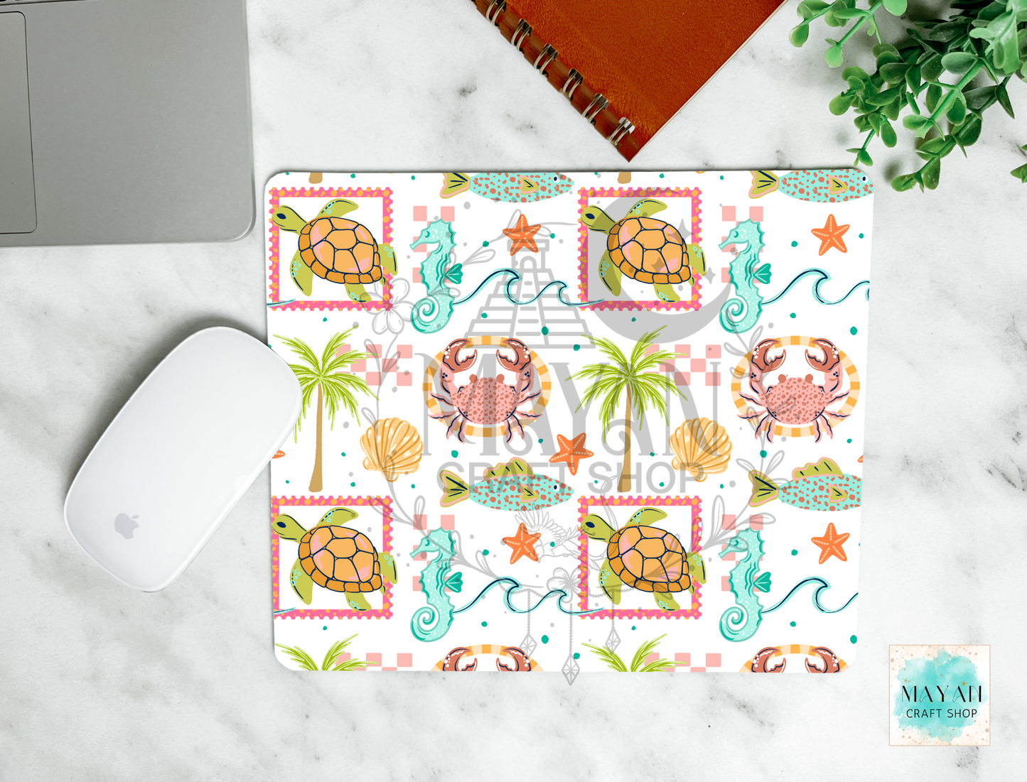 Mouse pad with sea-themed design featuring turtles, crabs, and seashells on a marble surface.