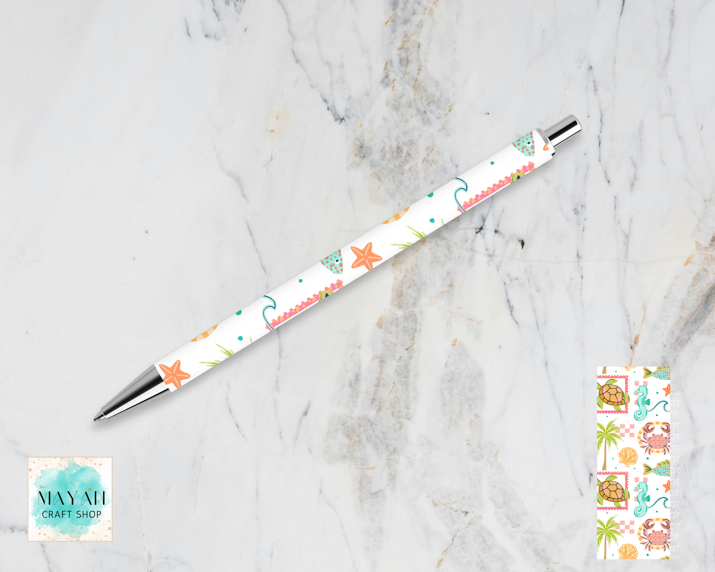 Decorative pen with starfish pattern on a marble surface, Maynil Craft Shop logo visible.