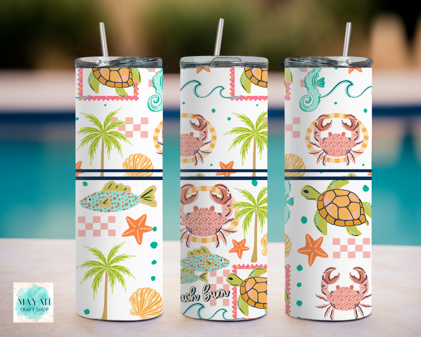 Three tumblers with beach-themed designs featuring palm trees, crabs, and sea turtles on a blurred pool background.