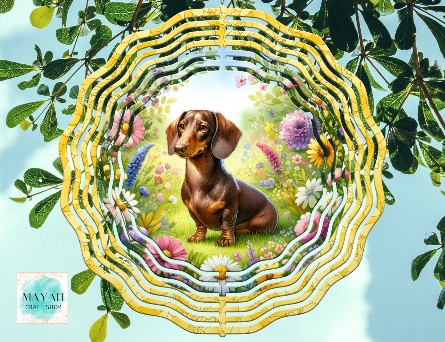 Decorative wind spinner with a dachshund surrounded by flowers and leaves.