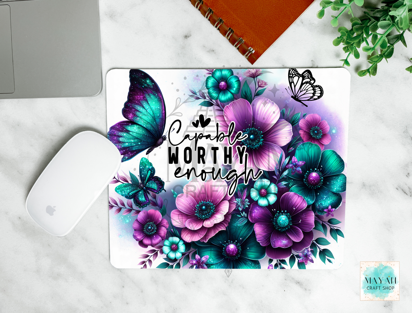 Floral mouse pad with motivational quote on a marble surface