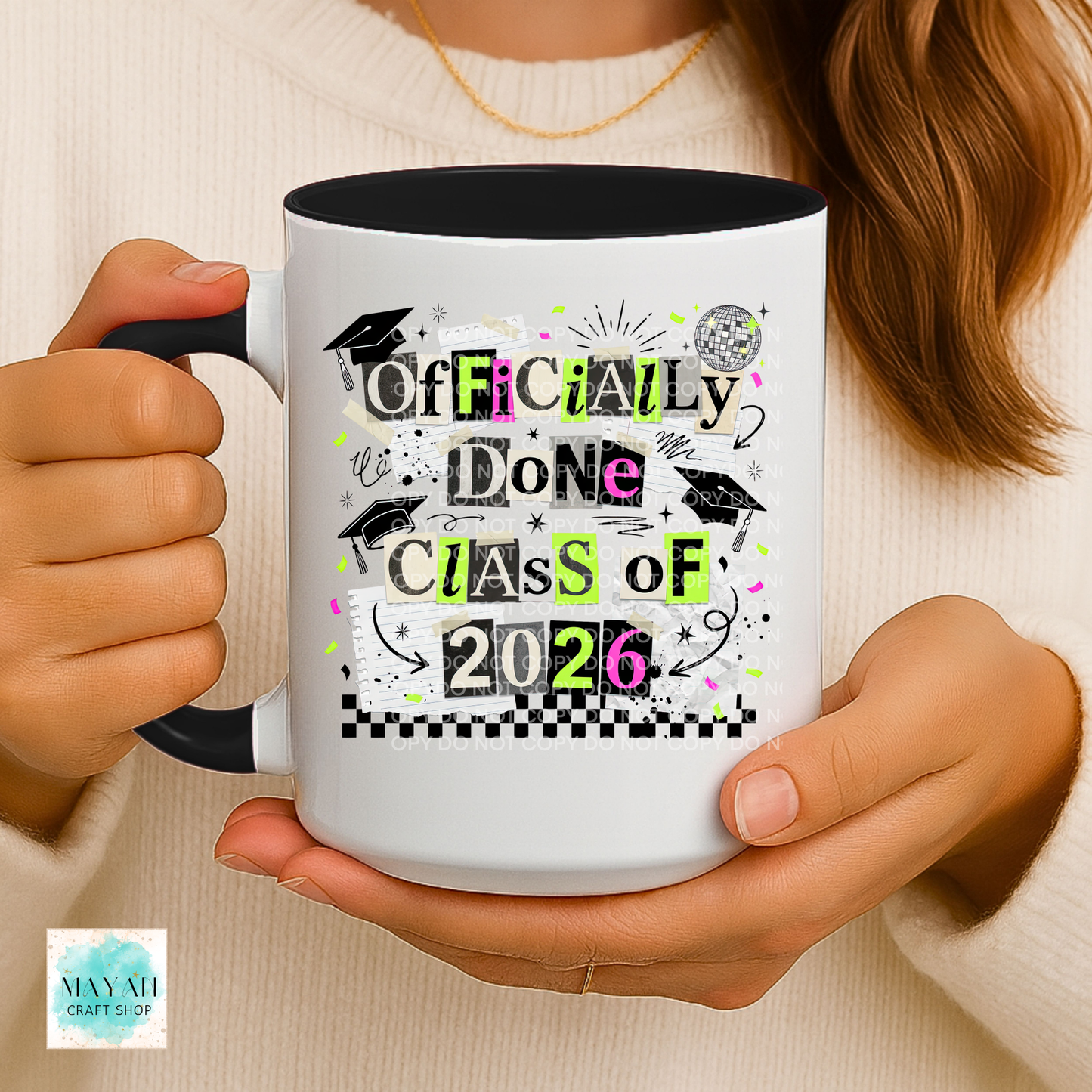 Person holding a mug with 'Officially Done Class of 2026' design