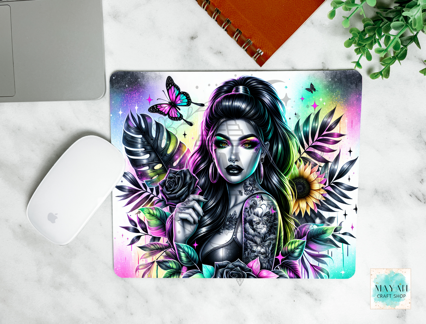 Colorful mouse pad with a design of a woman, flowers, and butterflies on a marble surface.