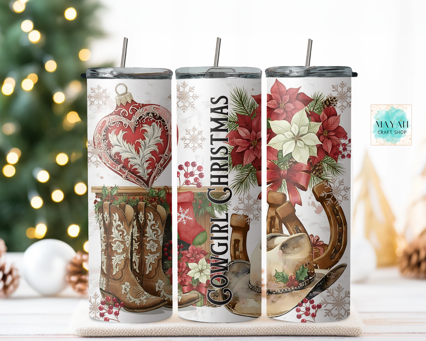 Three Christmas-themed tumblers with decorative designs on a table with a blurred background.