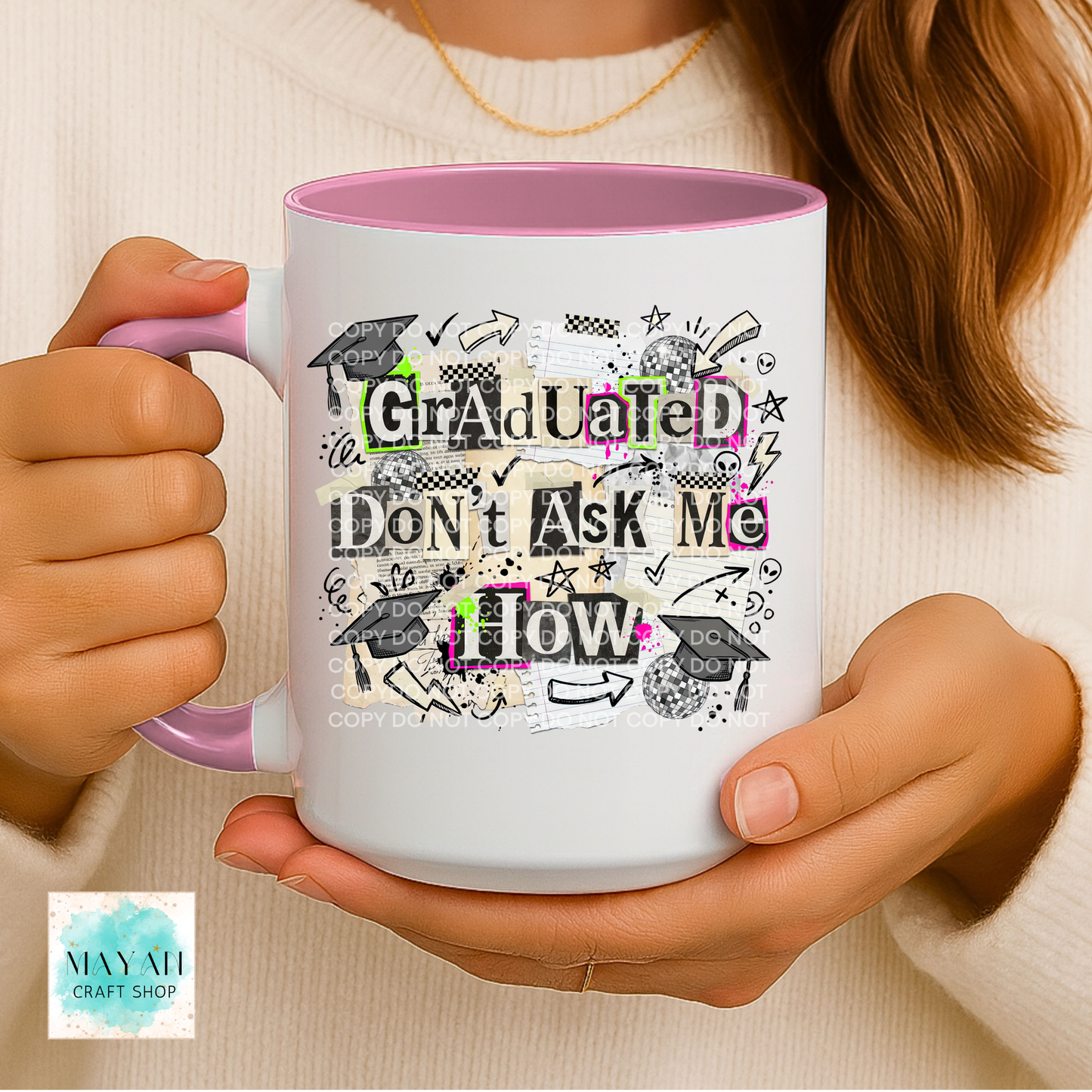 Person holding a mug with 'Graduated Don't Ask Me How' text and graduation-themed design.