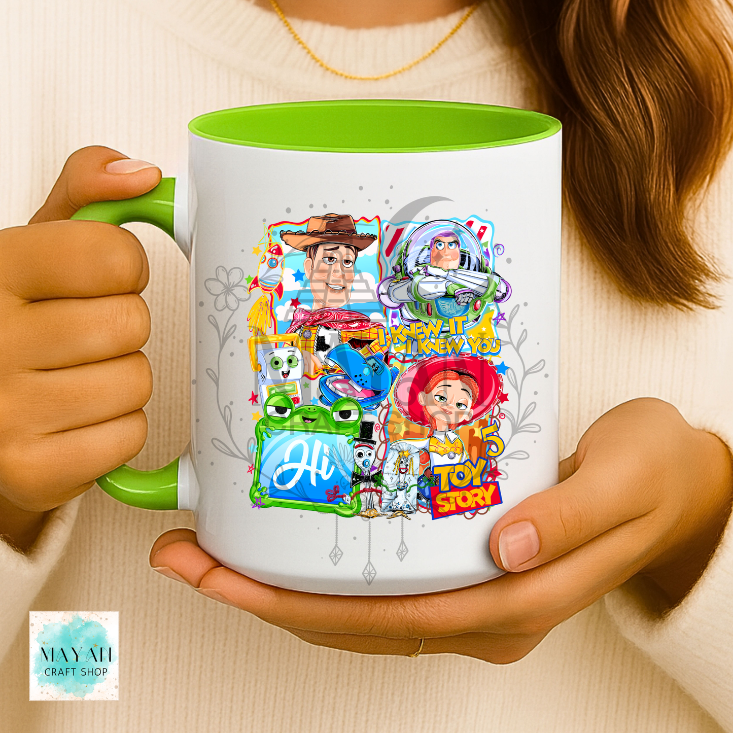 Person holding a mug with character designs on a light background