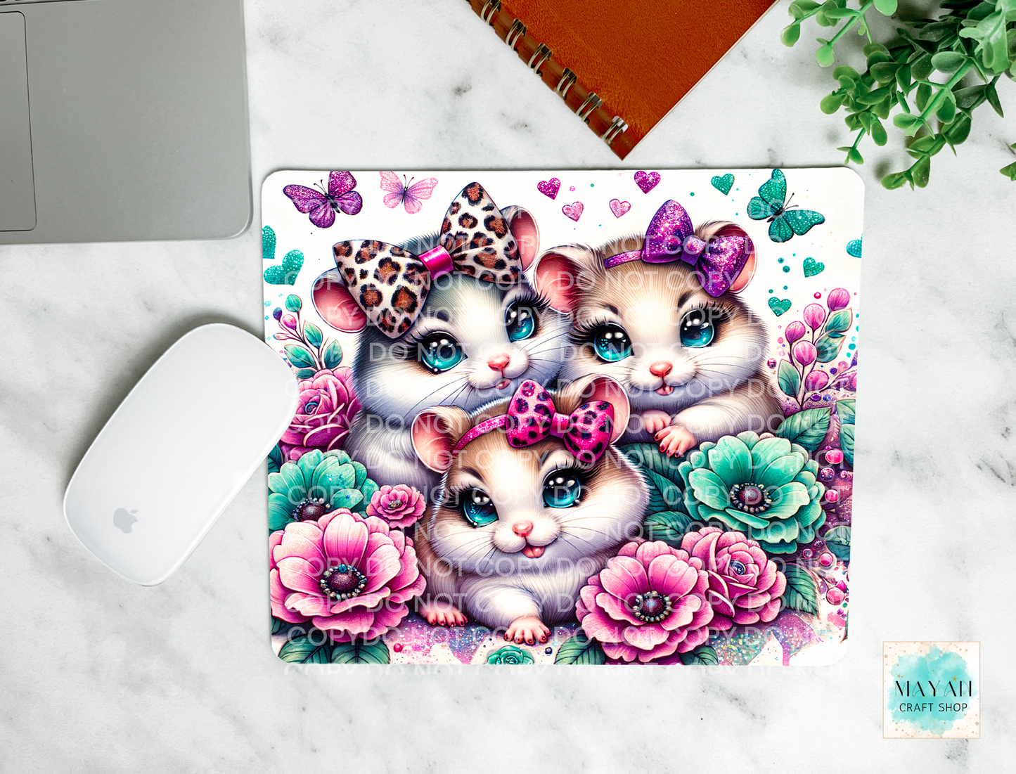Mouse pad with cartoon hamsters and floral design on a marble surface