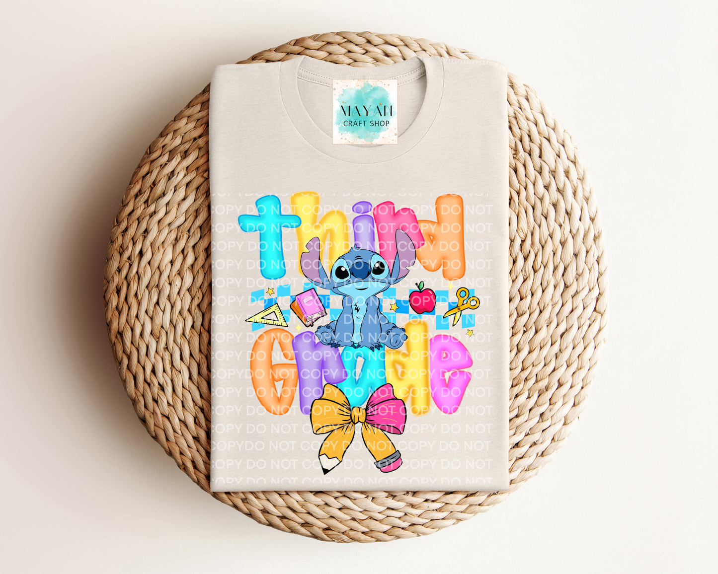 heather dust shirt with colorful design featuring a character and text on a woven round mat.