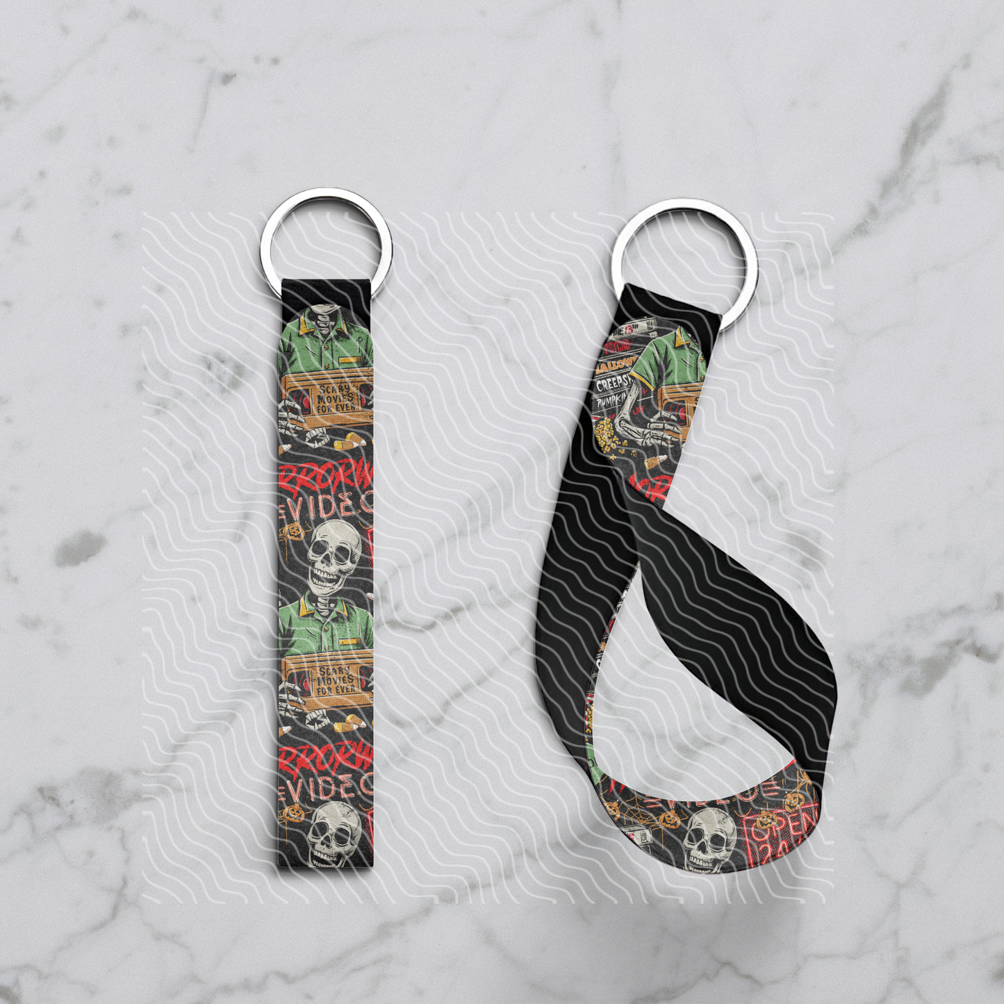 Two keychains with colorful designs on a marble surface