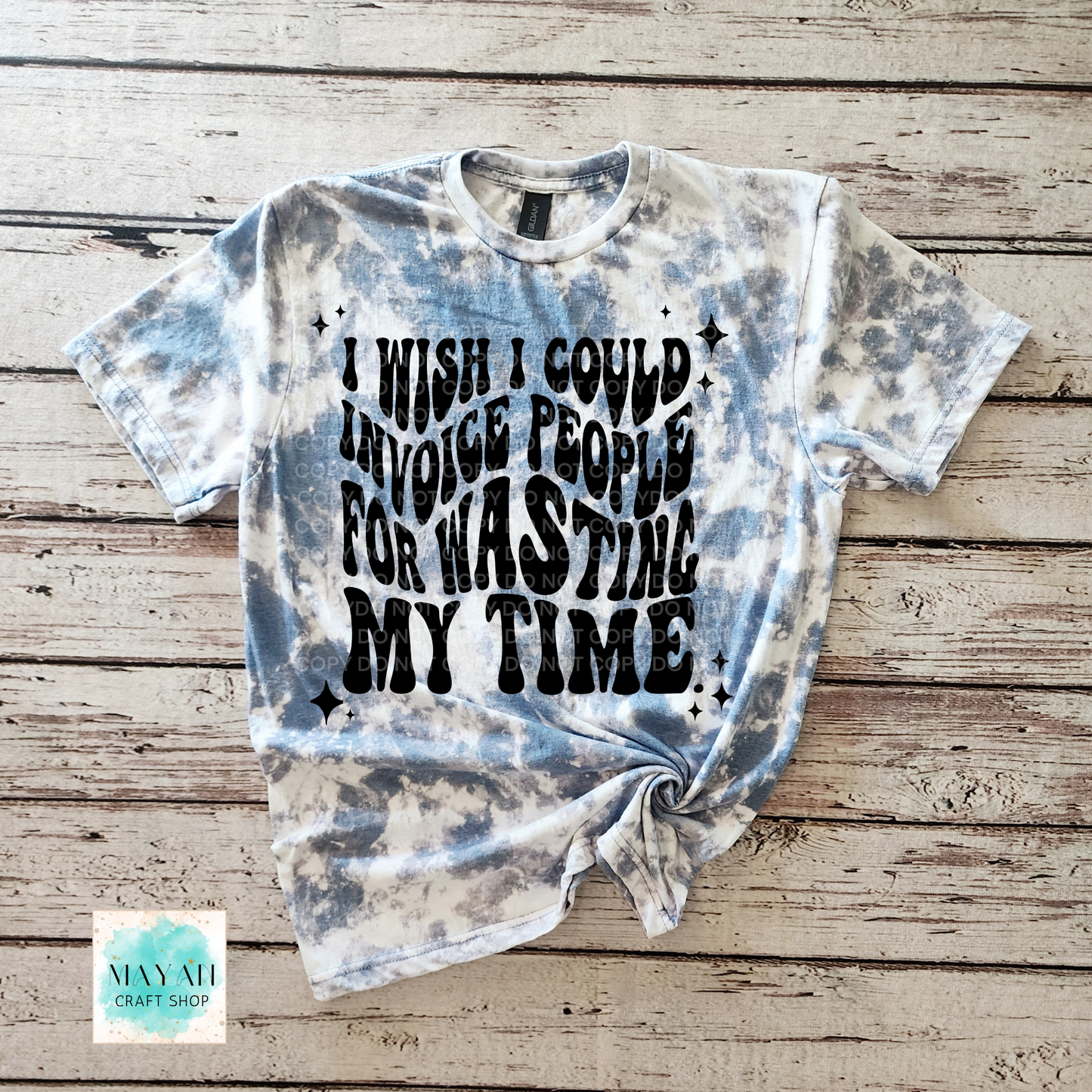 Bleached t-shirt with text on a wooden surface, featuring the brand 'Mayan Craft Shop'.