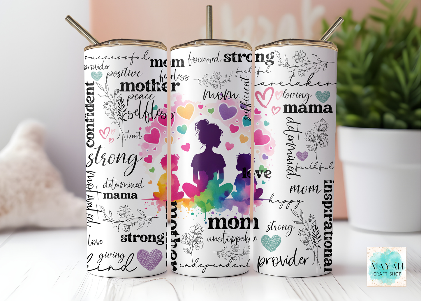 Set of three tumblers with colorful designs and text on a white surface.