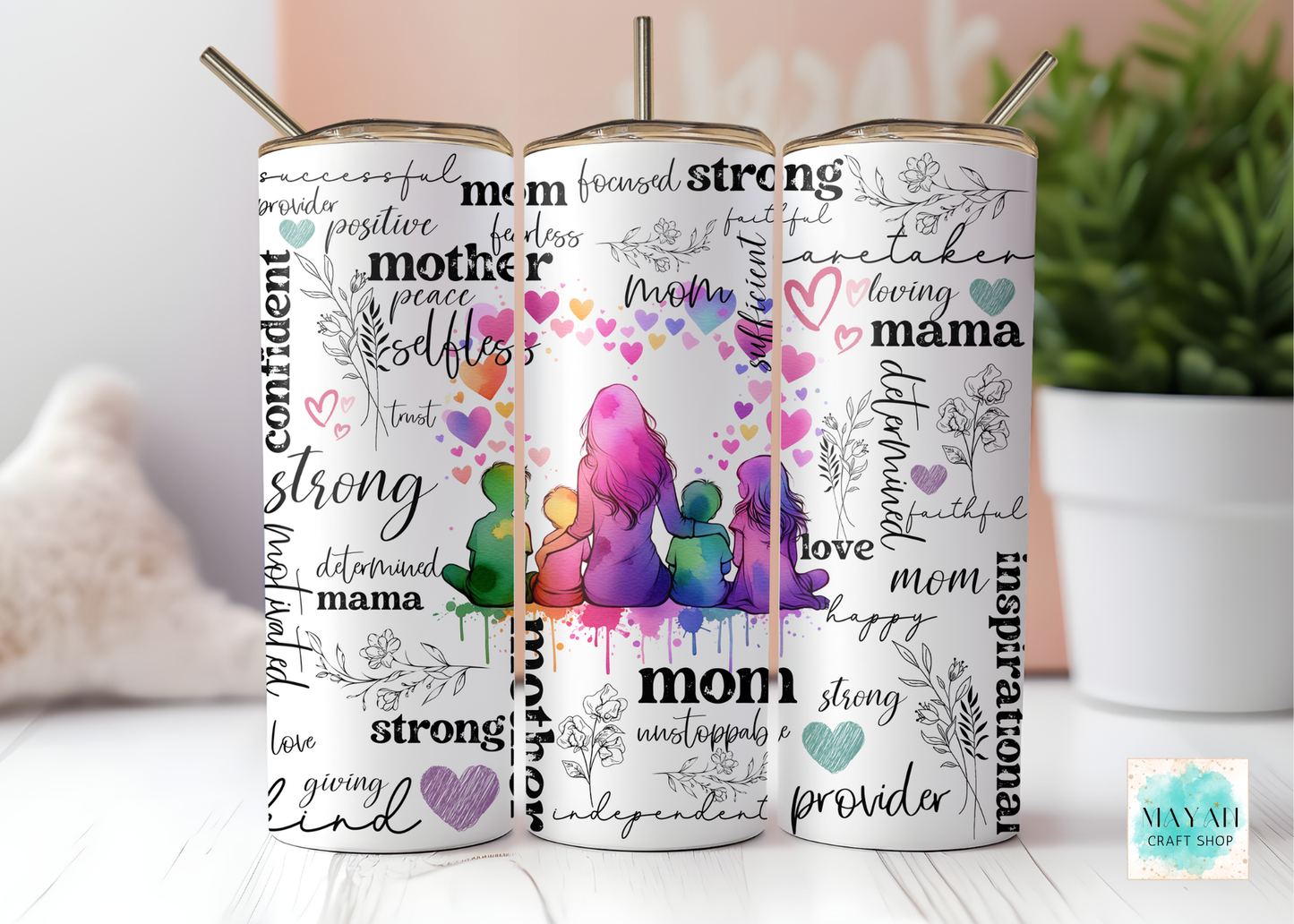 Three tumblers with motivational phrases and a colorful mother and child design on a white surface.