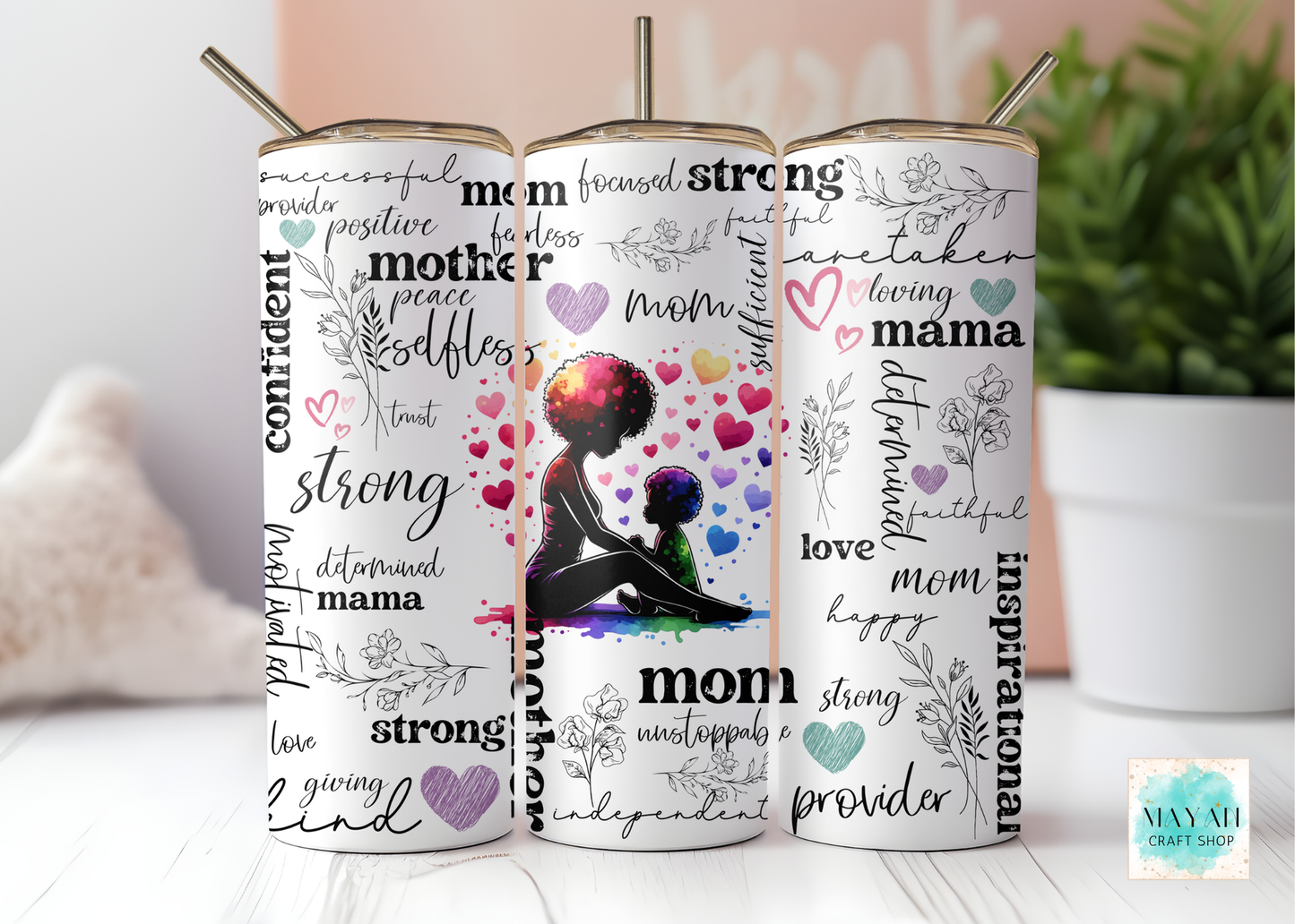 Three tumblers with motivational phrases and a silhouette of a woman on a white surface.