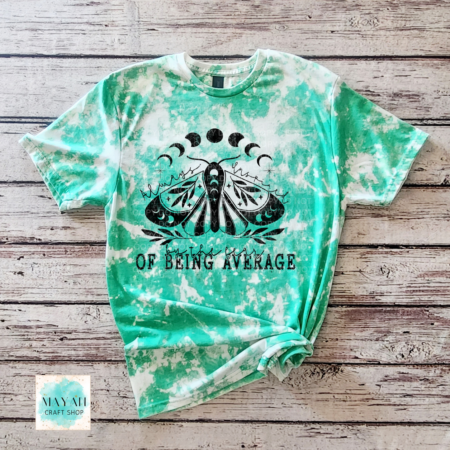 Tie-dye t-shirt with a butterfly design and text on a wooden surface