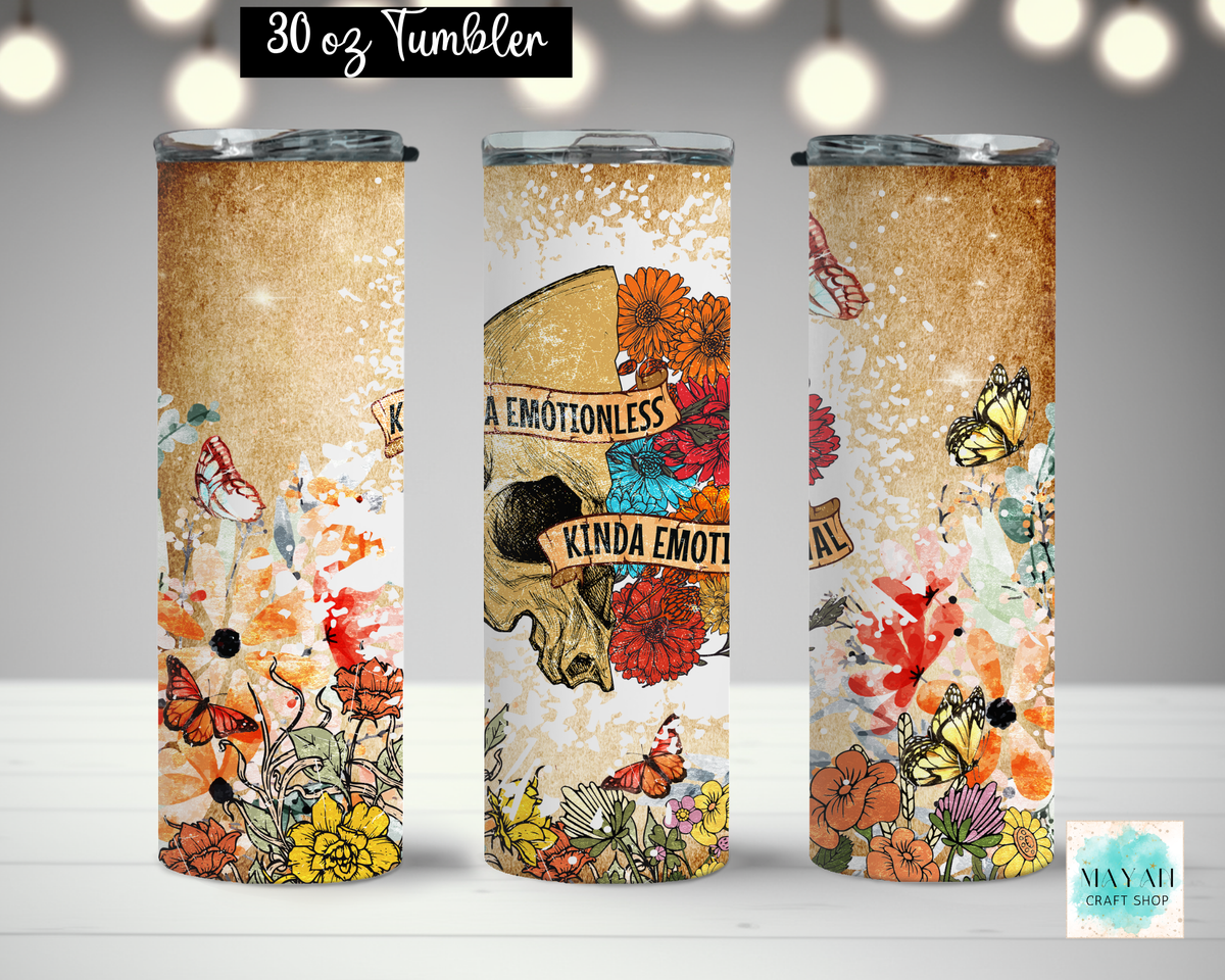 Three views of a 30 oz tumbler with a vintage-style graphic wrap. The design features a textured tan background with colorful illustrations of flowers, butterflies, and a skull with the text 'KINDA EMOTIONLESS'.