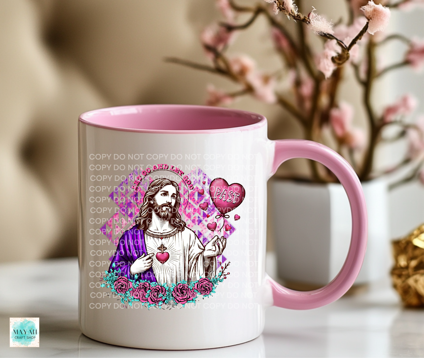 Mug with a colorful design of a religious figure, hearts, and flowers on a pink and white mug.