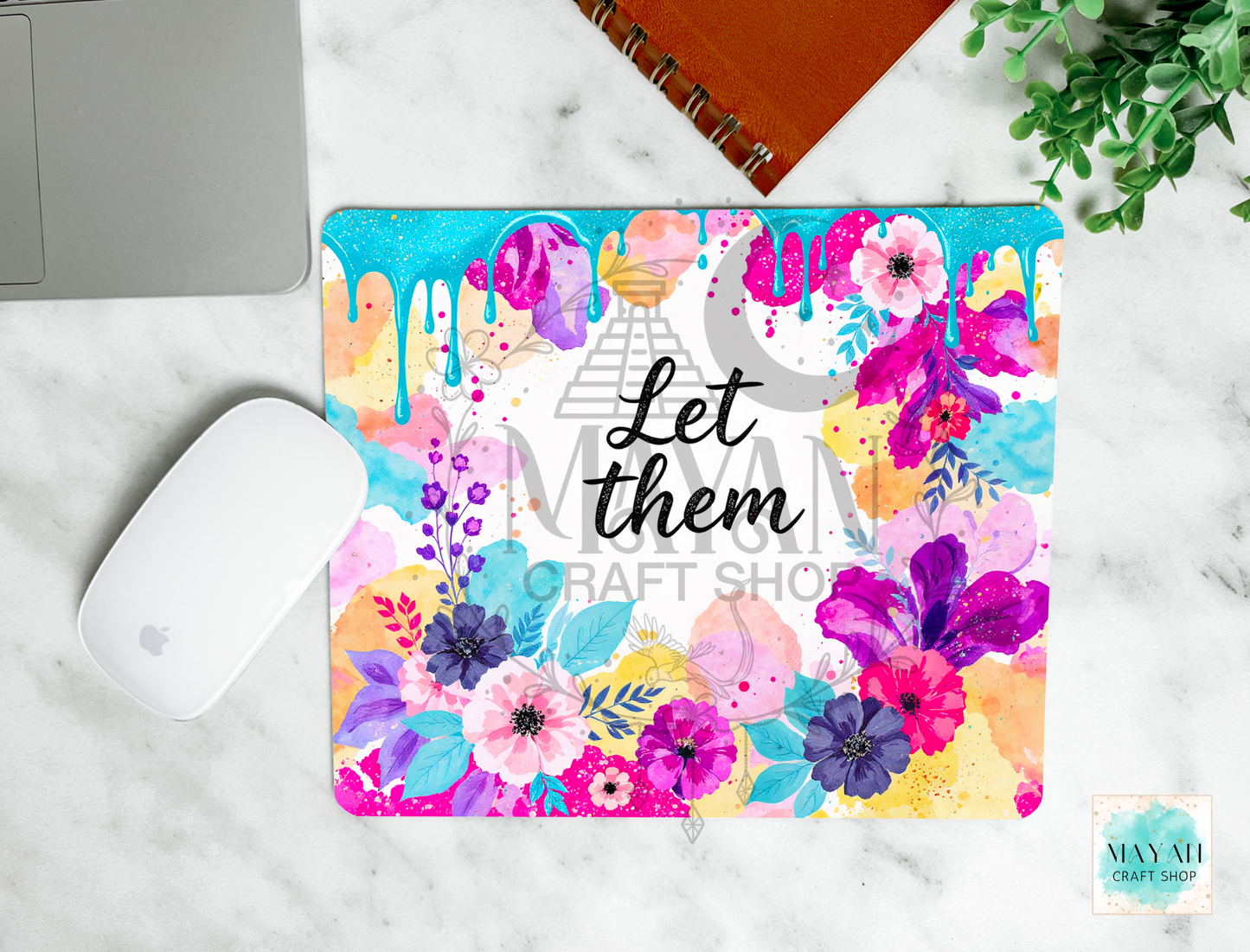 Colorful floral mouse pad with 'Let them' text on a marble surface.