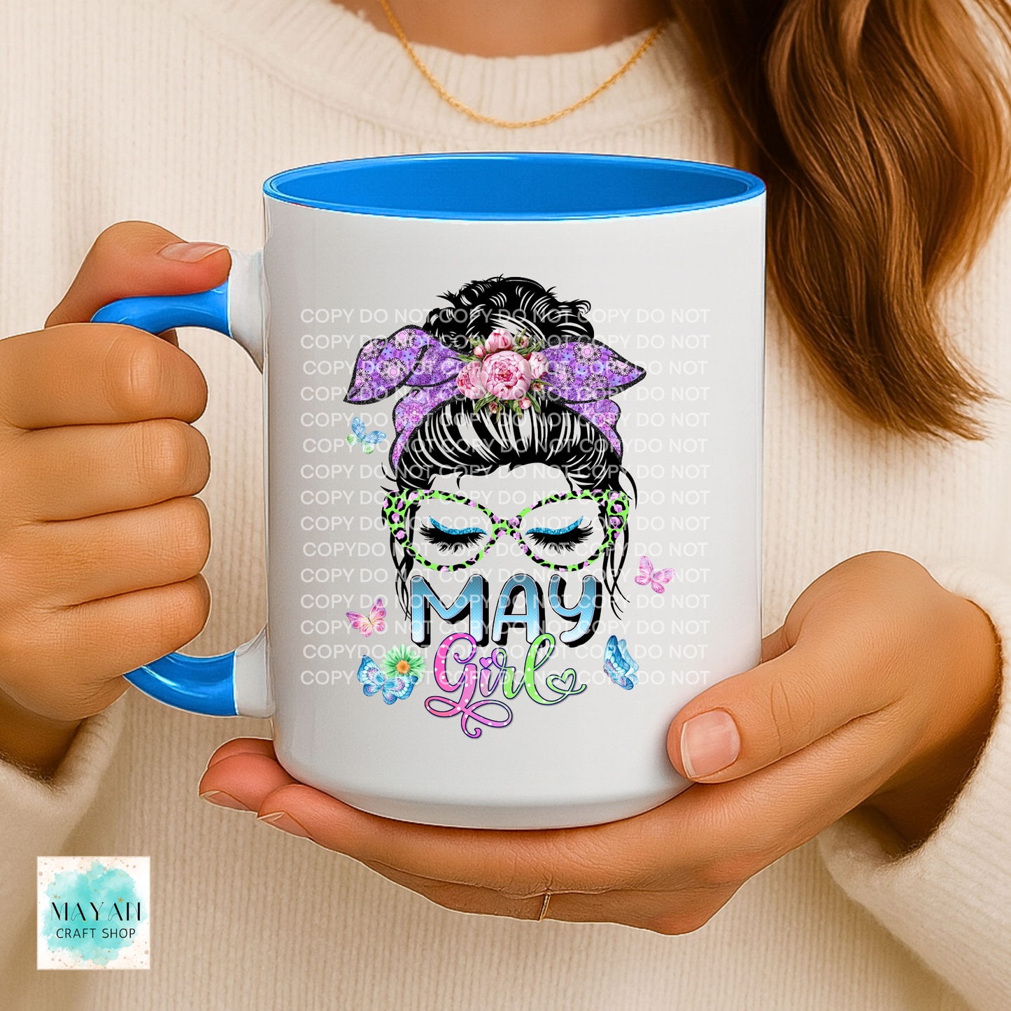 Person holding a mug with 'May Girl' design and blue interior.