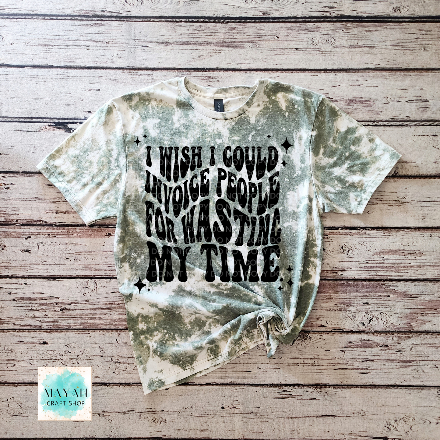 T-shirt with text on a wooden surface, featuring the brand 'Mayan Craft Shop'.