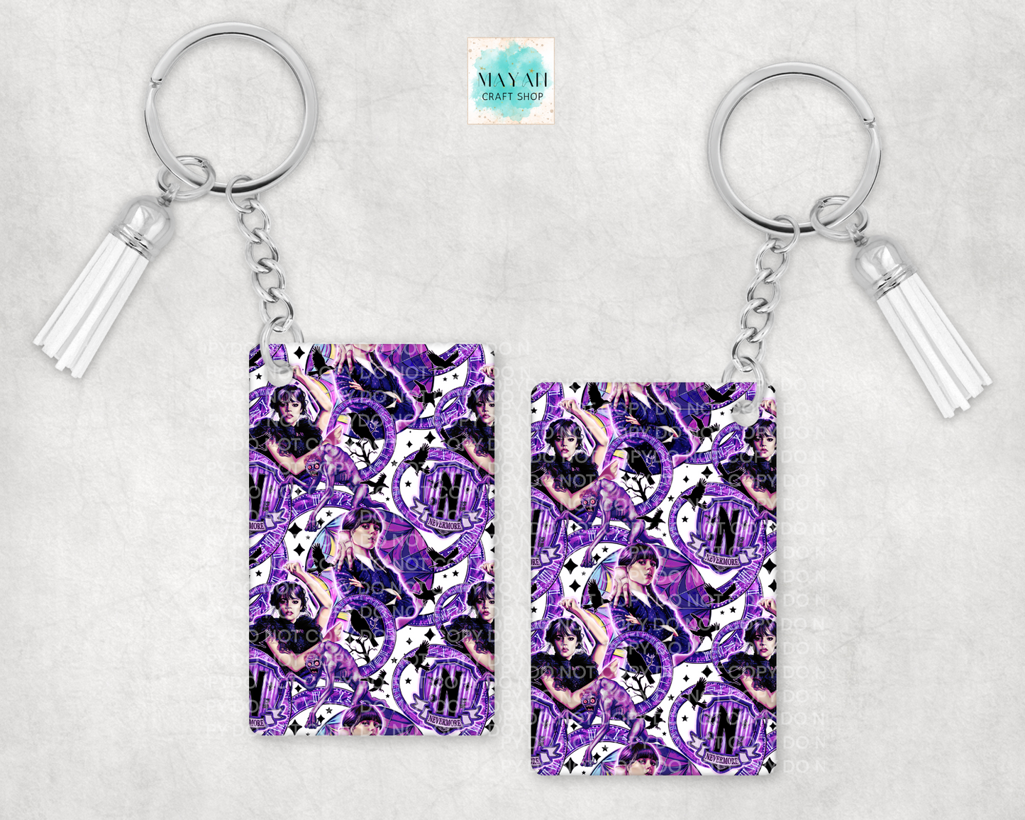Two keychains with a purple and white pattern on a light gray background