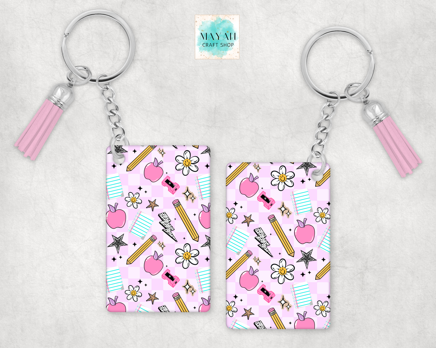 Two keychains with pink tassels on a light gray background