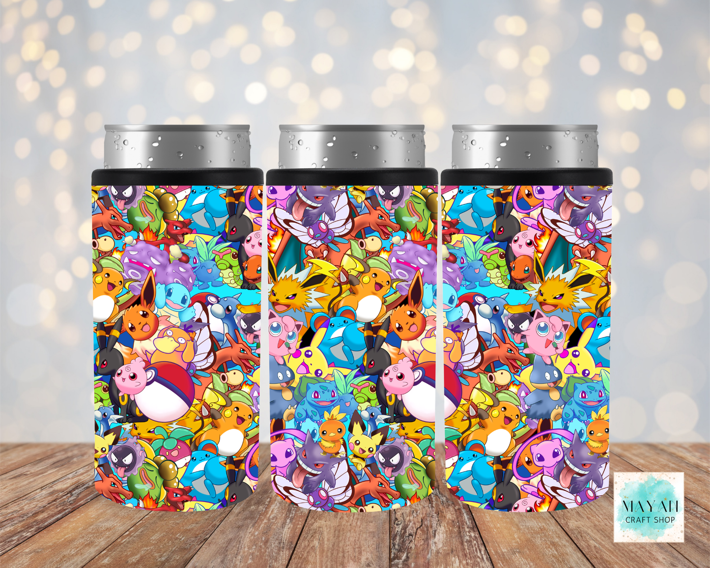 Three colorful tumblers with a cartoon character pattern on a wooden surface.