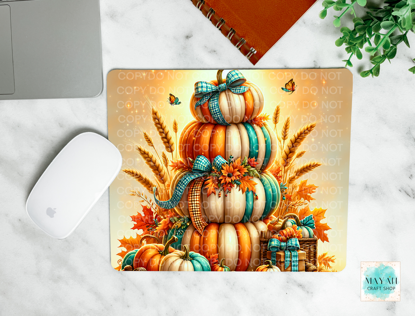 Decorative mouse pad with pumpkins and autumn elements on a marble surface.