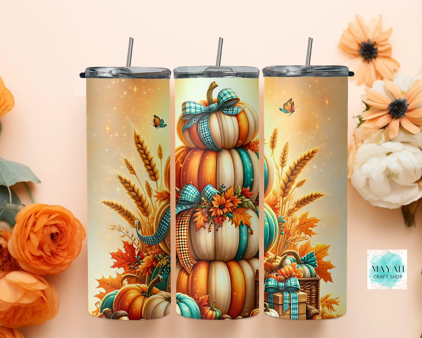 Three tumblers with autumn-themed designs featuring pumpkins, leaves, and wheat on a beige background.