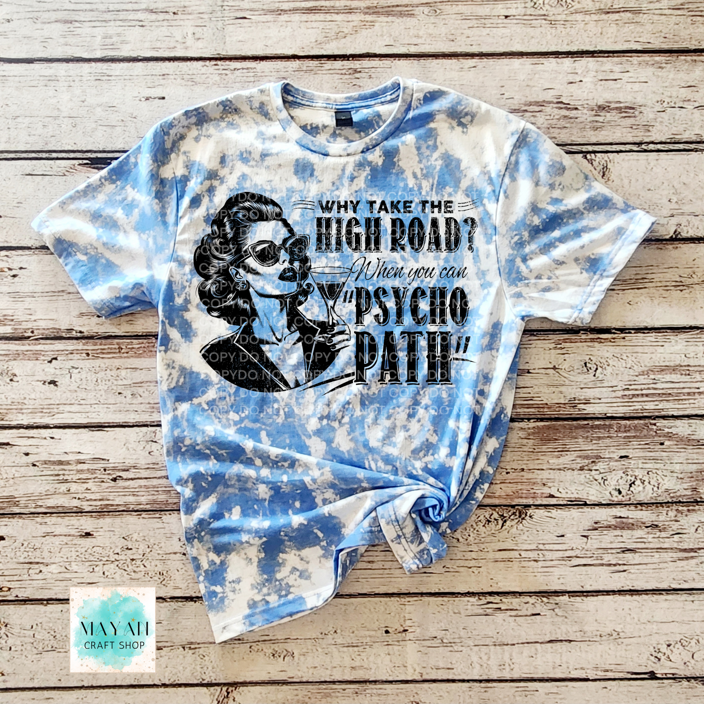 Tie-dye t-shirt with graphic design and text on a wooden surface
