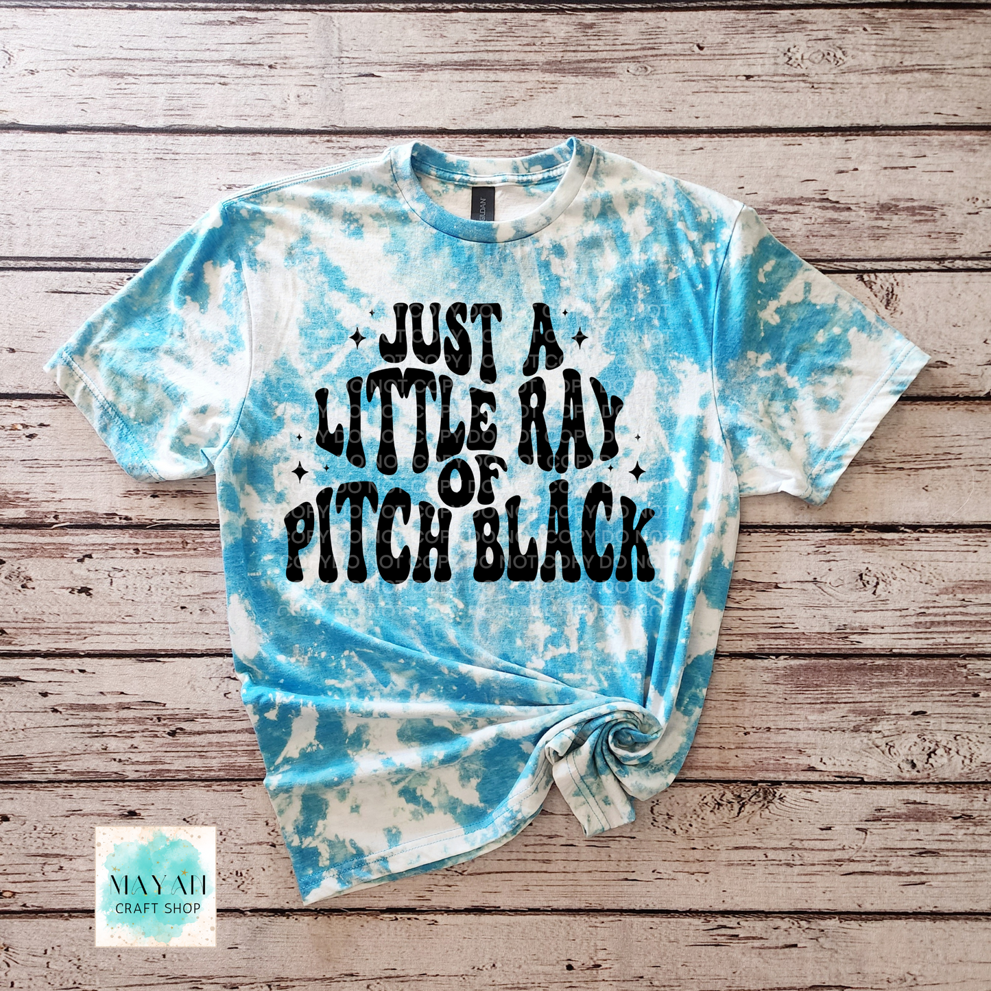Tie-dye t-shirt with text on a wooden surface
