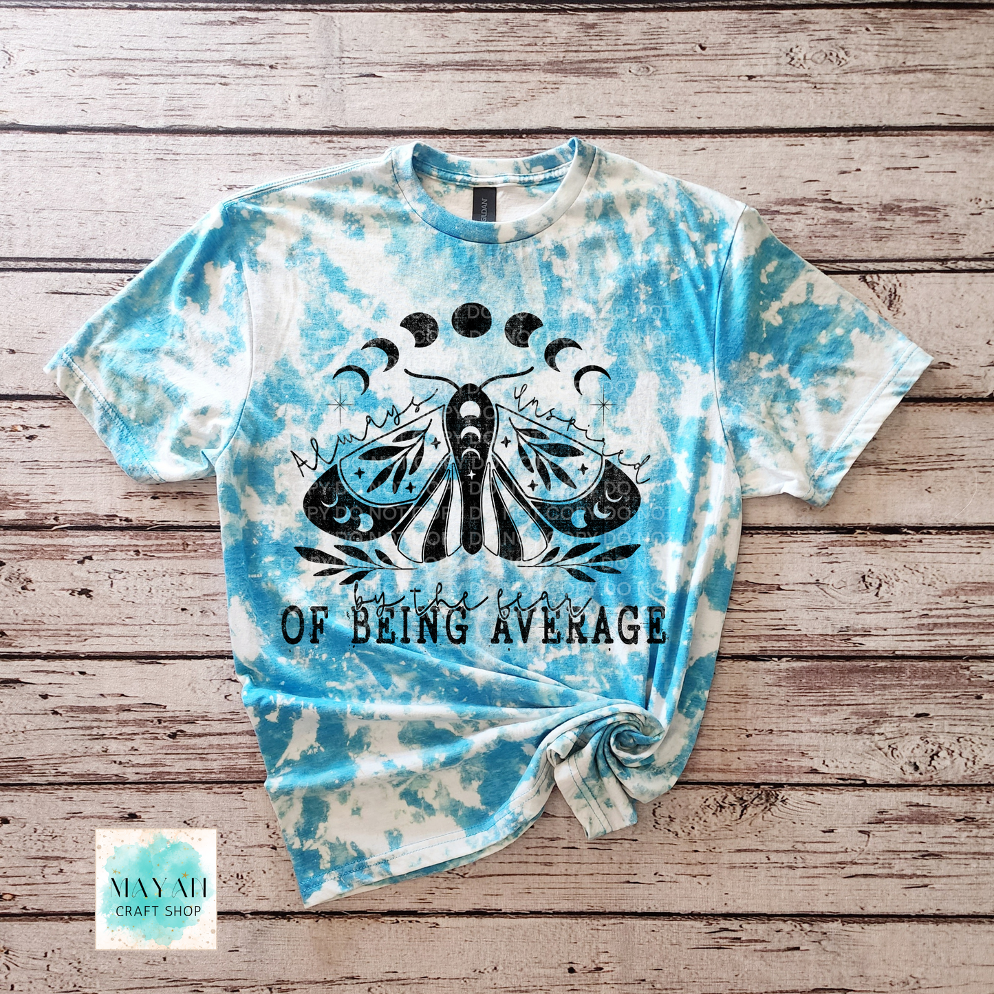 Tie-dye t-shirt with butterfly design and text on a wooden surface