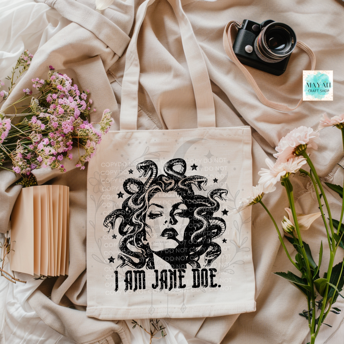 A canvas tote bag featuring a black graphic of Medusa with the text 'I AM JANE DOE.' printed on it.
