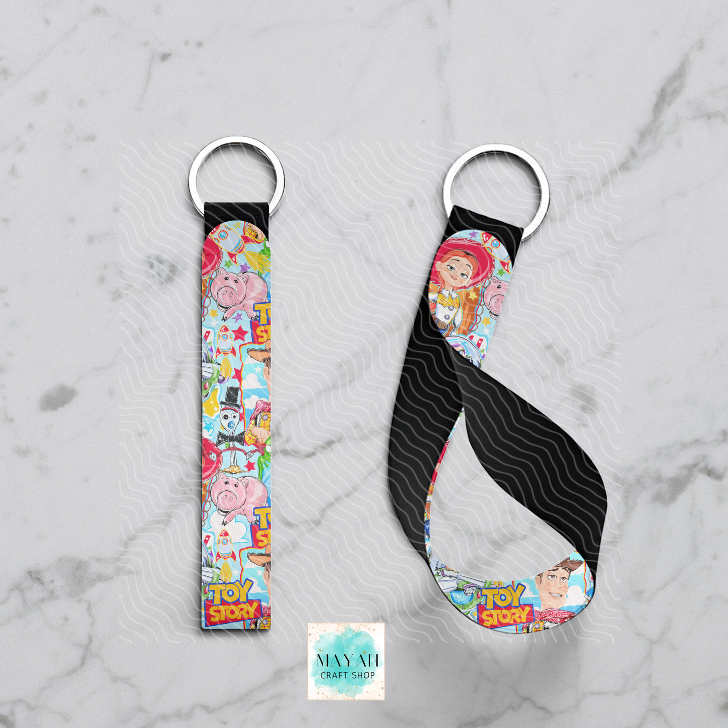 Two keychains with colorful designs on a marble surface, featuring characters.