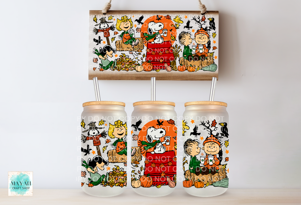 Three frosted glass mason jar tumblers with bamboo lids and metal straws, decorated with a Fall-themed print, displayed below a matching rectangular print. The print features characters in autumn costumes with pumpkins, and bats.