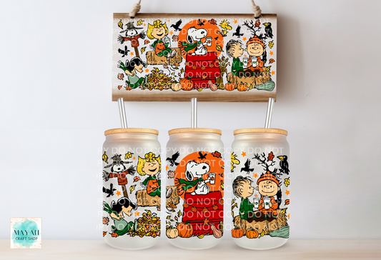 Three frosted glass mason jar tumblers with bamboo lids and metal straws, decorated with a Fall-themed print, displayed below a matching rectangular print. The print features characters in autumn costumes with pumpkins, and bats.