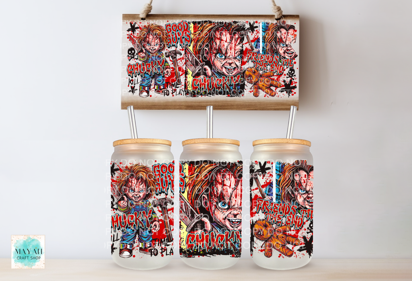 Three frosted glass mason jar tumblers with bamboo lids and metal straw inserts, each printed with a colorful horror character collage, shown below a matching rectangular print on a light wall.