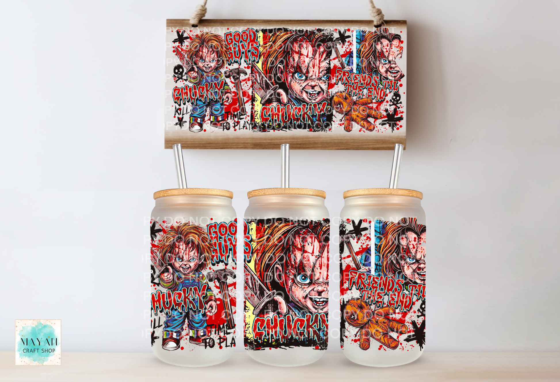 Three frosted glass mason jar tumblers with bamboo lids and metal straw inserts, each printed with a colorful horror character collage, shown below a matching rectangular print on a light wall.