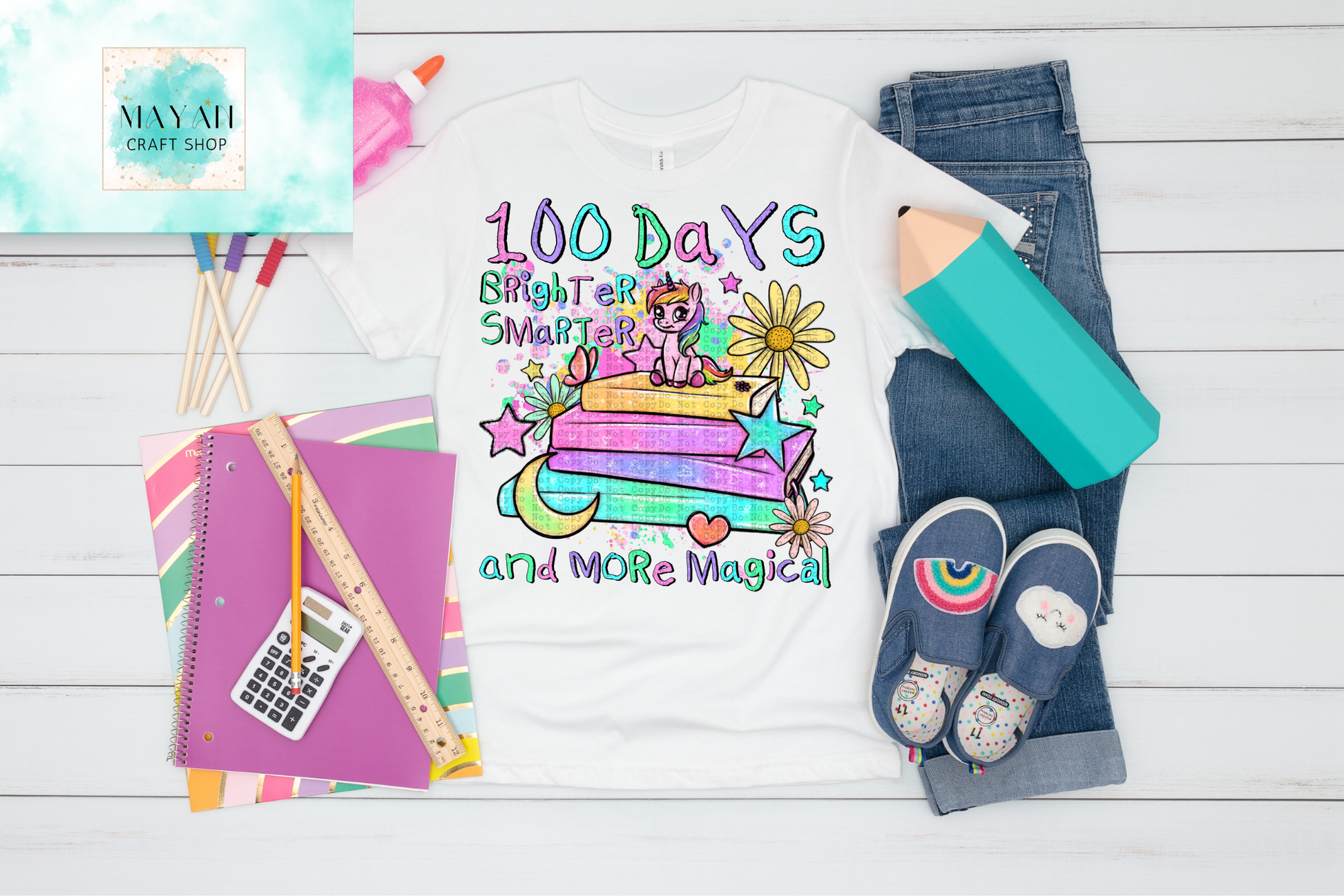 100 Days Brighter Smarter and More Magical shirt with school supplies on a wooden surface