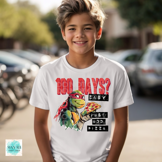 Child wearing a t-shirt with a graphic of a turtle holding a pizza and text, standing outdoors.