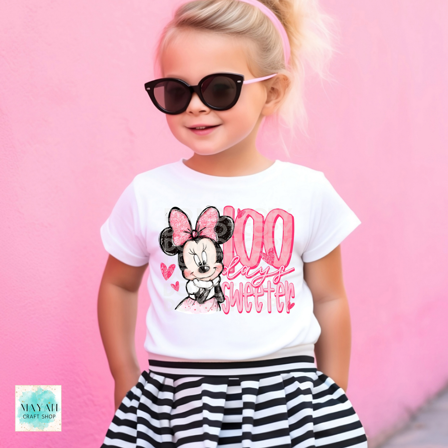 Child wearing a white t-shirt with a mouse graphic and sunglasses on a pink background