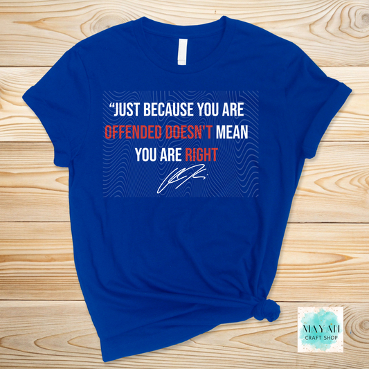 Blue t-shirt with a printed message on a wooden surface.