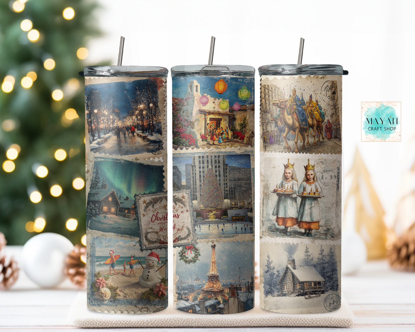 Three tumblers with vintage-themed designs on a surface with a Christmas tree in the background.