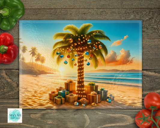 Decorative cutting board with a palm tree and presents on a beach at sunset, surrounded by vegetables on a wooden surface.