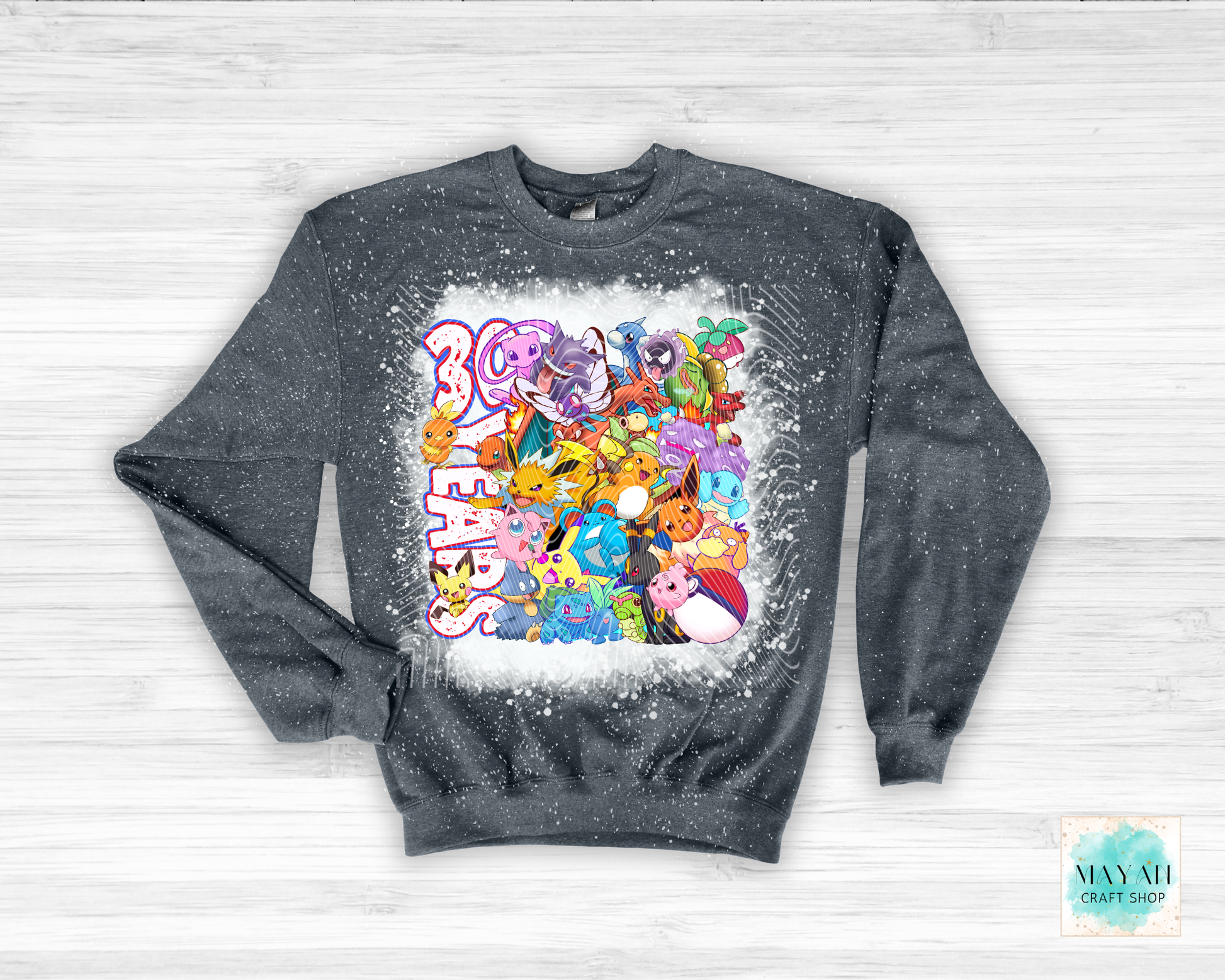 Gray sweatshirt with colorful graphic design on a white wooden background