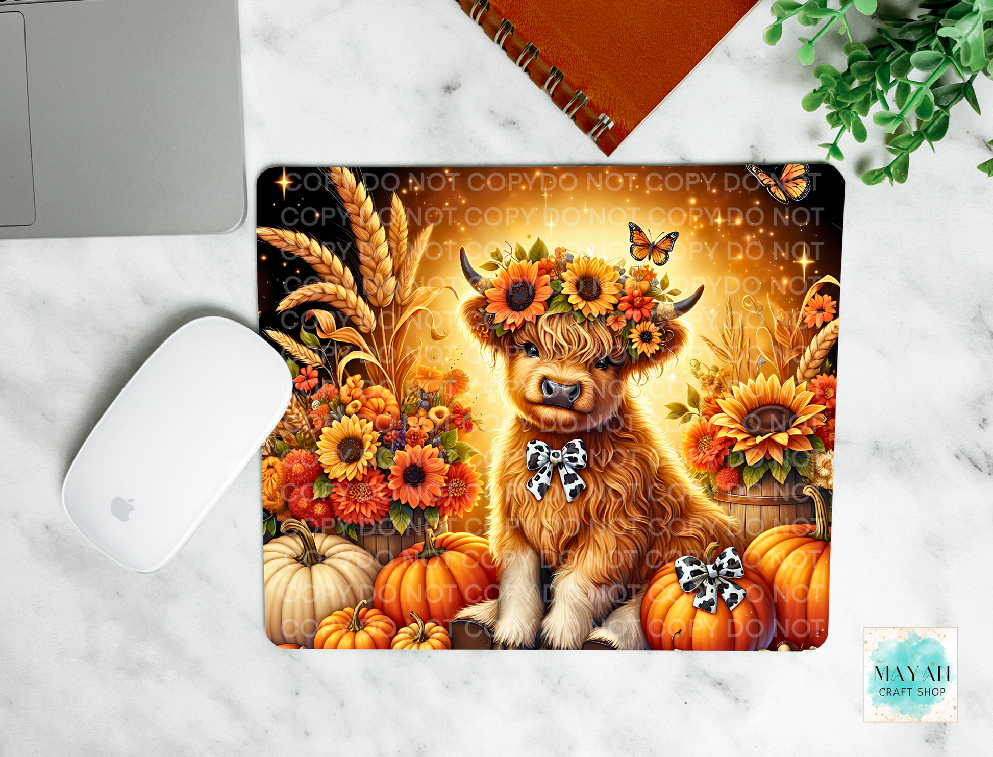 Decorative mouse pad with a highland cow wearing a flower crown surrounded by pumpkins and sunflowers on a marble surface.