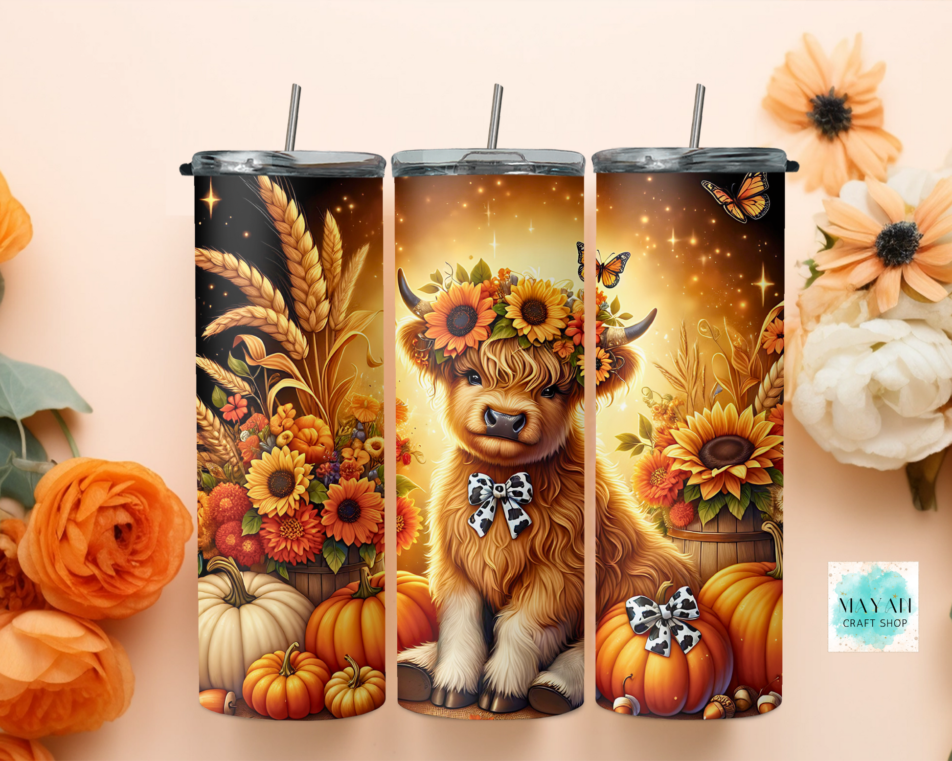 Three tumblers with autumn-themed designs featuring a cow, flowers, and pumpkins on a beige background.