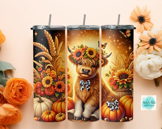 Three tumblers with autumn-themed designs featuring a cow, flowers, and pumpkins on a beige background.