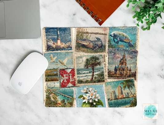 Decorative mouse pad with vintage-style postage stamp designs on a marble surface.